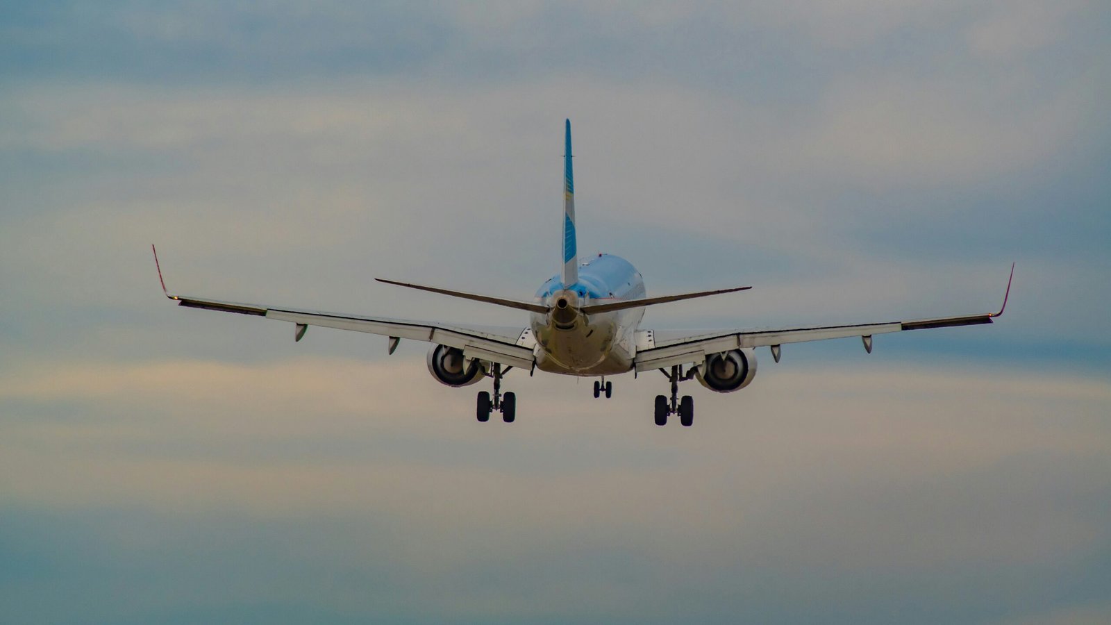 white and blue airplane in mid air during daytime